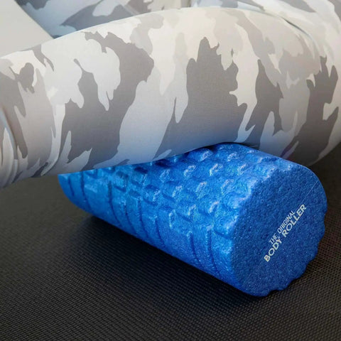 High Density Foam Roller Massager With 3D Textured Rollers for deep tissue back and leg muscle massage under legs in workout gear.