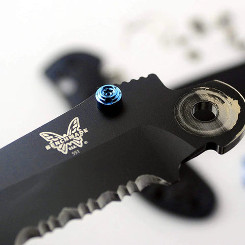 Close-up of blue titanium thumb stud installed on a black 535 Bugout blade, part of the ZYAMY 3pcs Thumb Studs Replacement set.