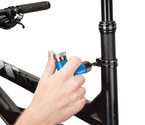 Using Park Tool ATD-1.2 Adjustable Torque Driver Tool, Blue, on bicycle frame for precise torque adjustment.
