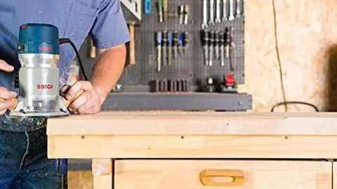 Person using Fixed Base Router 2.25 HP 12 Amp Variable Speed 8000 to 25000 RPM for precise edge work on wooden surface