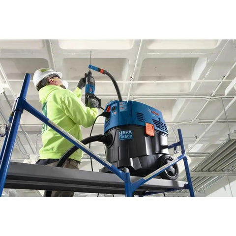 Worker using One And One Eighth Inch SDS-Plus Bulldog Xtreme Max Rotary Hammer For Concrete Drilling And Chiseling In Masonry on ceiling
