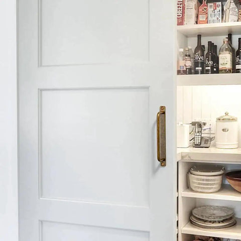 Set Of 12 Antique Brass Cabinet Pulls With Back Plates, Center To Center 5 Inch Length, installed on white cabinet door