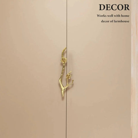 Close-up of Brass Flower Branch Cabinet Handle 5.91 Inch Blossom Drawer Pull Knob on beige cupboard door.