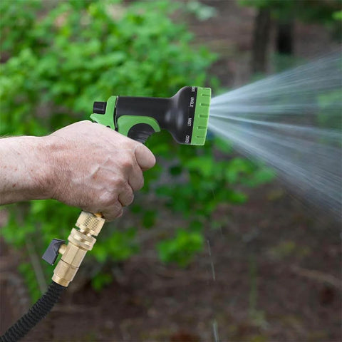 Hand holding hose with Solid Brass Garden Hose Quick Connect Set With 3/4 Inch GHT spraying water in garden