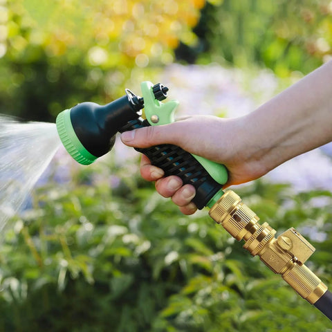 Hand using durable brass garden hose quick connect fittings 3/4 GHT quick coupler with sprinkler in outdoor setting