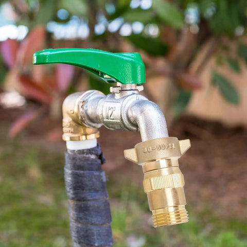 Brass RV Water Pressure Regulator With Filter Screen for campers and travel trailers, installed on hose, 40-50 PSI regulation.