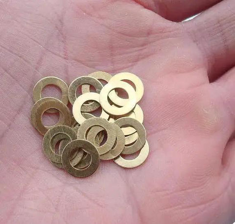 Hand holding Brass Washer Gasket Set For Knife Pivot Pins 20 Pcs Replacement, corrosion-resistant spacers for smooth blade action.