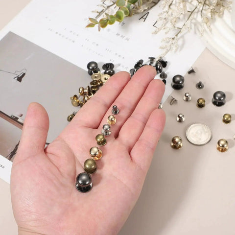 Hand holding Bronze Ball Head Leather Rivet Set 20 Pieces with various sizes, Chicago Style for handbags and belts repairs.
