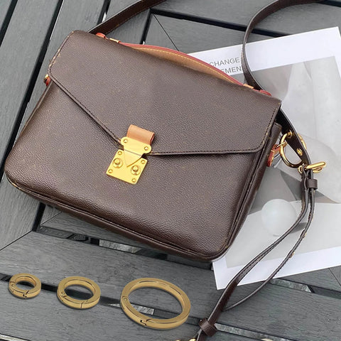 Handbag on table with 2 Pack 1 Inch Spring O Rings For Purses And Handbags, Gold Finish, Easy Spring Opening Clips, rust resistant zinc alloy