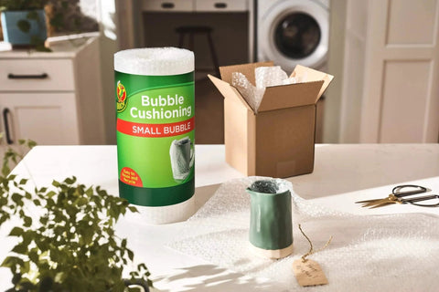 Bubble Wrap Protective Packaging 12 Inch Wide 30 Foot Roll for delicate items next to a carton box on a kitchen countertop.