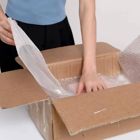 Person using 2 Pack 12 Inch Bubble Packing Wrap 72 Feet Perforated Every 12 Inches for Moving Boxes and Shipping Cushioning