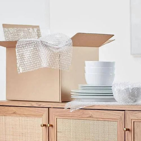 Bubble Cushioning Wrap For Fragile Items Perforated 12 Inch Roll 175 Ft Clear With Small Three Sixteenth Inch Bubbles next to dishes