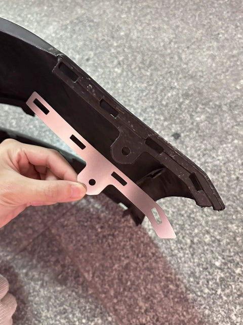 Hand holding Beefed Up Front Bumper Repair Metal Plate For Ford Fusion 2013 To 2016 next to bumper clip area