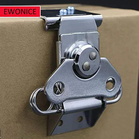 Close-up of a small butterfly twist latch with keeper plate in zinc plated steel, installed on a cardboard surface for secure closure.