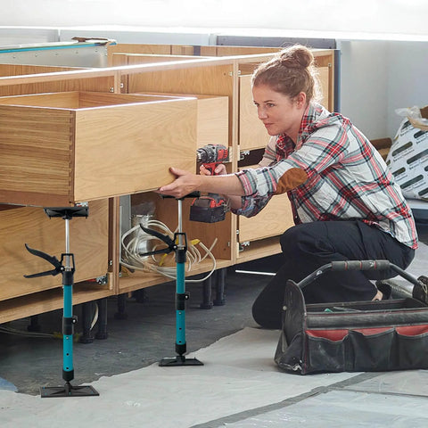 Woman using adjustable support poles, cabinet jacks for installing cabinets, telescoping support poles range from 13.8'' to 24.6'', 2 packs