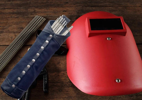 Durable Canvas And Leather Welding Rod Bag For Electrode Storage And Welding Tools next to red welding mask on wooden surface