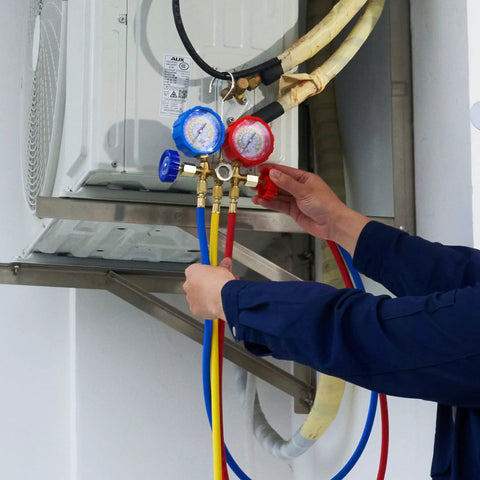 3-way AC manifold gauge set with blue and red gauges, 5 ft hoses, connected to an outdoor air conditioner.