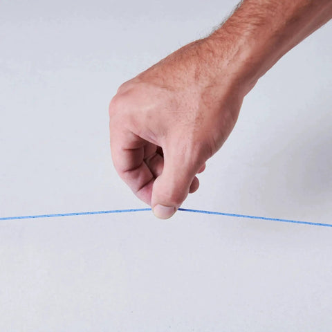 Hand holding blue line from Durable ABS Tuff Line contractor chalk reel delivers precise layout marking, ideal for construction.