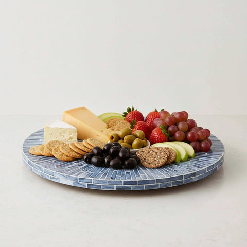 12.6 inch mother of pearl lazy susan turntable with blue starburst design featuring cheese, fruits, and crackers on a decorative tray.