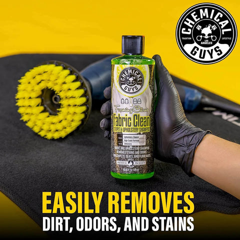 Chemical Guys Foaming Citrus Fabric Clean bottle held with cleaning tools in the background, 16 oz size