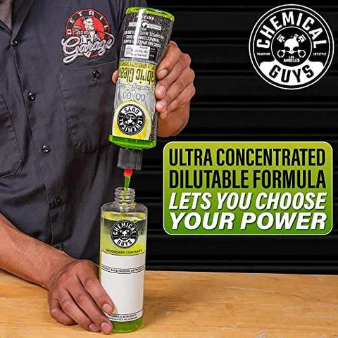 Person pouring Chemical Guys Foaming Citrus Fabric Clean, Carpet and Upholstery Cleaner - Car Carpet Cleaner for Seats, and Floor Mats, Safe for Home, Office & More, Citrus Scent - 16 oz into a bottle with black background.