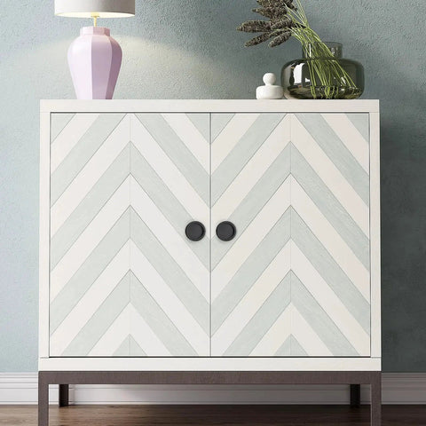 Chevron pattern cabinet with circular handles under decorative items, lamp, and plants on top.