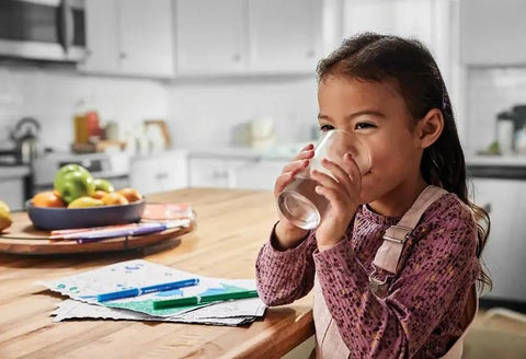 Child drinking water in kitchen with PureSource Ultra Water Filter ULTRAWF Replacement For Refrigerator Delivers Fresh Clean Tasting Water