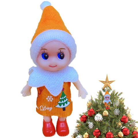 Toy elf doll in orange outfit standing next to decorated Christmas tree with similar elf as ornament
