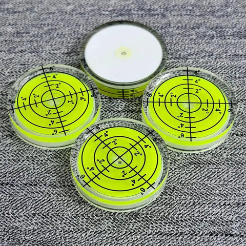 Four small circular bubble levels on a textured surface, 32x7mm acrylic, used for DIY woodworking alignment, Pro Grade Easy To Read.