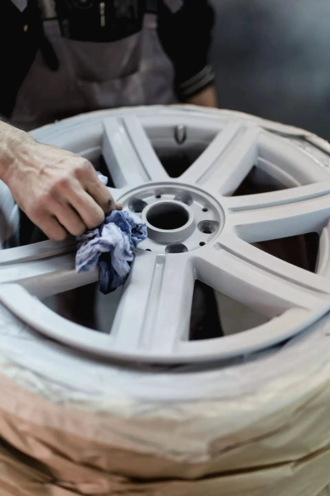 Person using Fine Grade Aluminum Oxide Sandblasting Media 12 Lb Bag For Metal Glass Stone And Wood Cleaners Etching Finishing Premium Long Lasting Abrasive For Sand Blasters Blasting Cabinets And Guns to clean alloy wheel