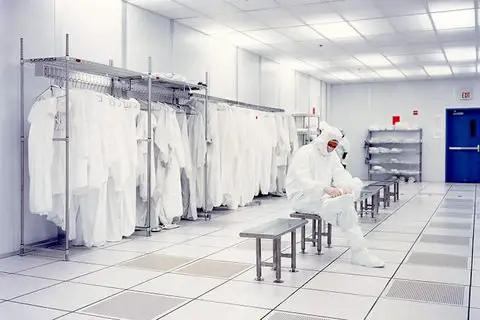 Cleanroom environment with person in protective gear, emphasizing use of White PVC Cleanroom Tape 2 Inch By 36 Yards One Roll That Handles Solvents
