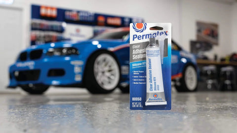Clear RTV Silicone Adhesive Sealant 3 Oz Sensor Safe General Purpose Sealant For Inside Or Outside Use packaging in a garage.
