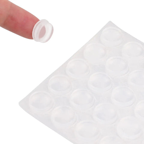 Clear Self Adhesive Cabinet Door Bumpers Set 300 Piece For Drawers And Cupboards Rubber Stoppers on sheet with finger holding one piece