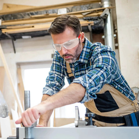 Man wearing Clear ANSI Z87.1 Safety Eyewear For Men And Women Scratch Resistant Lenses while working in workshop