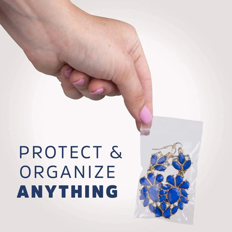Hand holding Clear Plastic Reclosable ZIP Bags 2 Mil 2x3 Inch Case of 100, containing blue jewelry for safe storage.