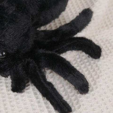 Close-up of Ultra Soft Black Spider Plush Toy For Kids And Adults, showing detailed plush fur and legs on a cream surface