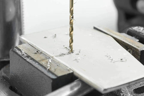 Bosch 14-Piece Cobalt M42 Drill Bit Set in action, drilling through a metal sheet, showcasing durability and precision use on stainless steel.