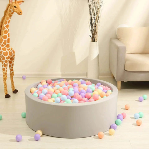 Colorful Ball Pit Balls - Pink Soft Plastic Balls Phthalate Free BPA Free Play Balls for Ball Pool Birhtday Party Girls Kids with Storage Bag, 6Colors,100pcs in a round grey ball pit with a giraffe toy and sofa in the background.