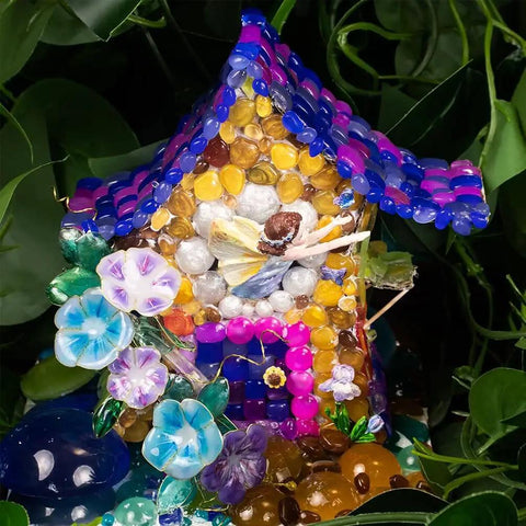 Colorful fairy house made of beads with a fairy figurine, surrounded by vibrant flowers made from the Cabochon Gem Resin Silicone Molds.