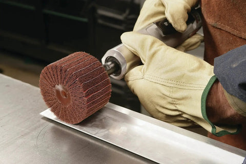 Worker using Combi S Wheel P180 Grit Aluminum Oxide with X Weight Backing on die grinder for metal finishing.