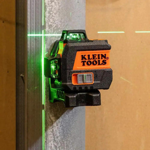 Compact self-leveling laser level with bright green cross lines and 360-degree planes mounted on a metal surface for precise alignment.