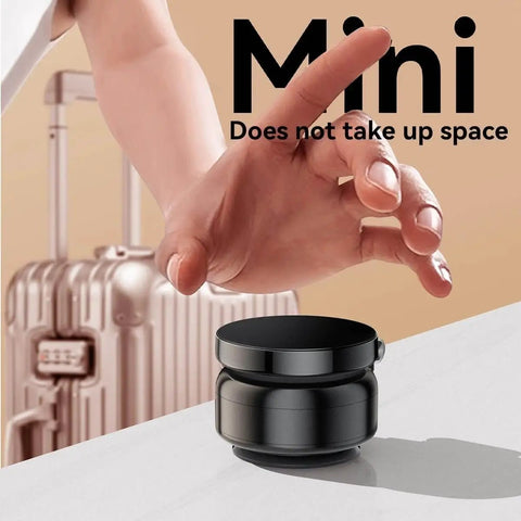 Hand reaching for mini Magnetic Phone Holder With Vacuum Grip Technology on surface, luggage in background.