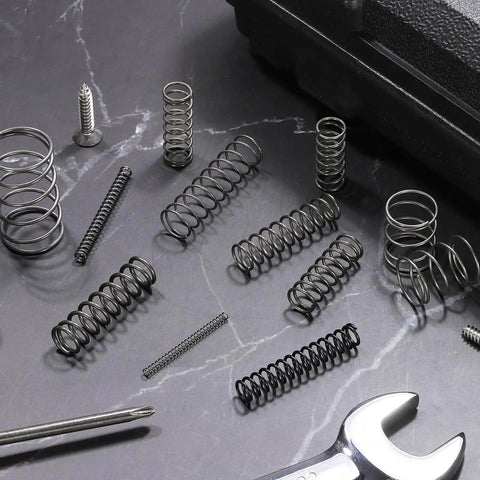 30 Pack Compression Springs 13mm OD, 1.2mm Wire Size, 15mm Free Length, Spring Steel Construction, arranged on a workshop surface