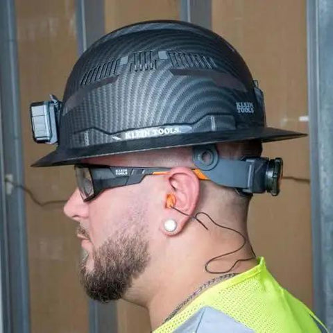 Side view of a person wearing Corded Reusable Earplugs with 25dB NRR in bright orange, suitable for construction and loud environments.