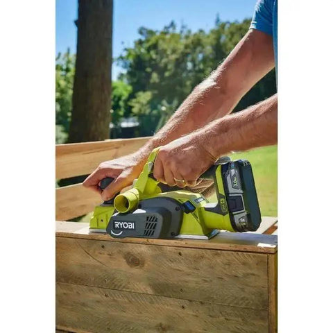 Person using Cordless 18V Planer with a compact 3-1/4 inch width and included dust bag on wooden surface outdoors