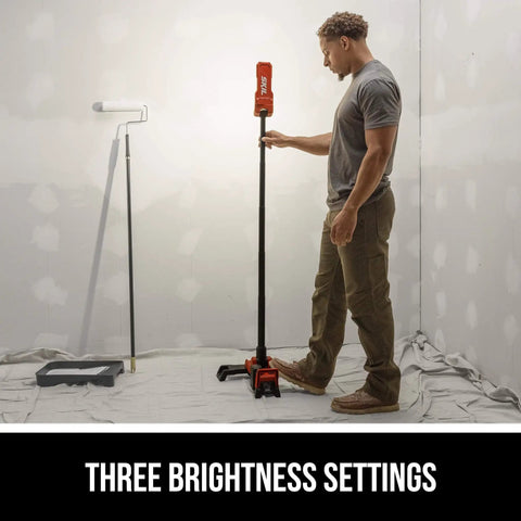 Man adjusting Cordless Compact Tower Light Kit With 20V Power Includes A 2.0Ah USB C Battery And USB C Charger, Works With PWR CORE 12V Or 20V Batteries, Fast Tool Free Setup With Fold Out Legs And Adjustable Brightness For Job Sites, shown on job site with paint supplies.