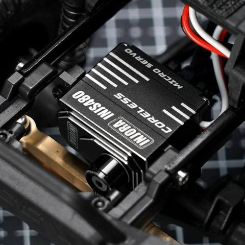 Close-up of a Coreless Micro Servo with Servo Horn for 1/24 Axial SCX24 RC Crawler(Black) installed in an RC vehicle chassis.