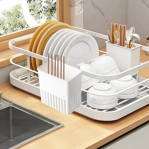 Cutlery Drying Rack - Utensil Drainer - Cutlery Drainer for Sink holding dishes and utensils on a kitchen countertop next to a sink.