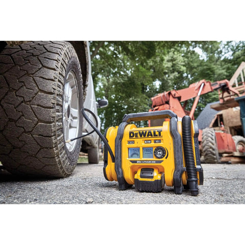 DEWALT Tire Inflator Portable Air Compressor 20V MAX, Car Air Pump with Automatic Shut Off, LED Light, Tool Only (DCC020IB) next to tire