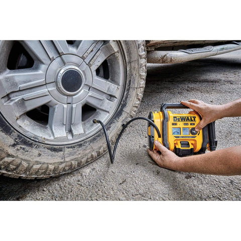 Person using DEWALT Tire Inflator Portable Air Compressor 20V MAX, Car Air Pump with Automatic Shut Off, LED Light on vehicle tire